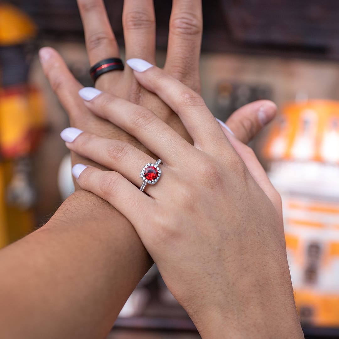 couples hands with halo ruby engagement ring