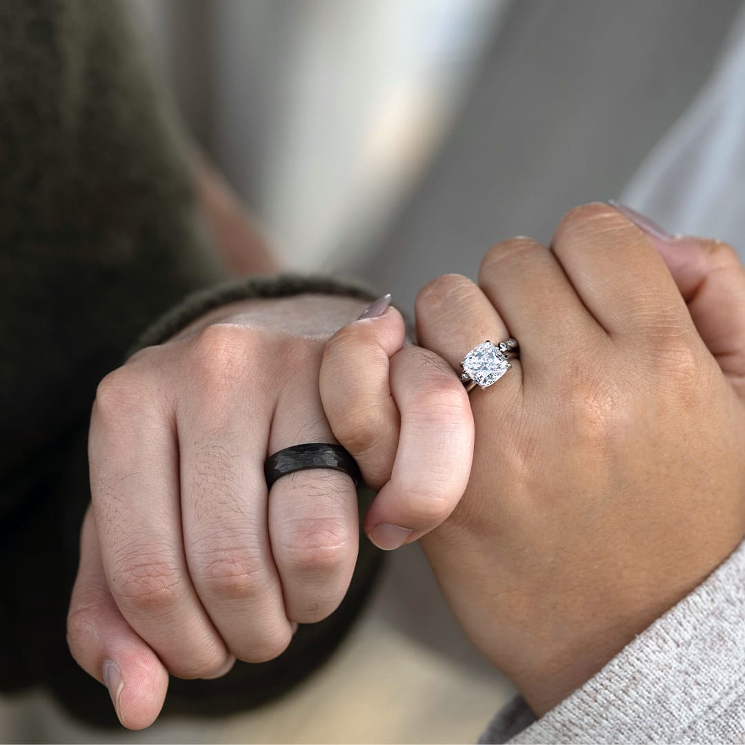 couple holding hands with wedding rings