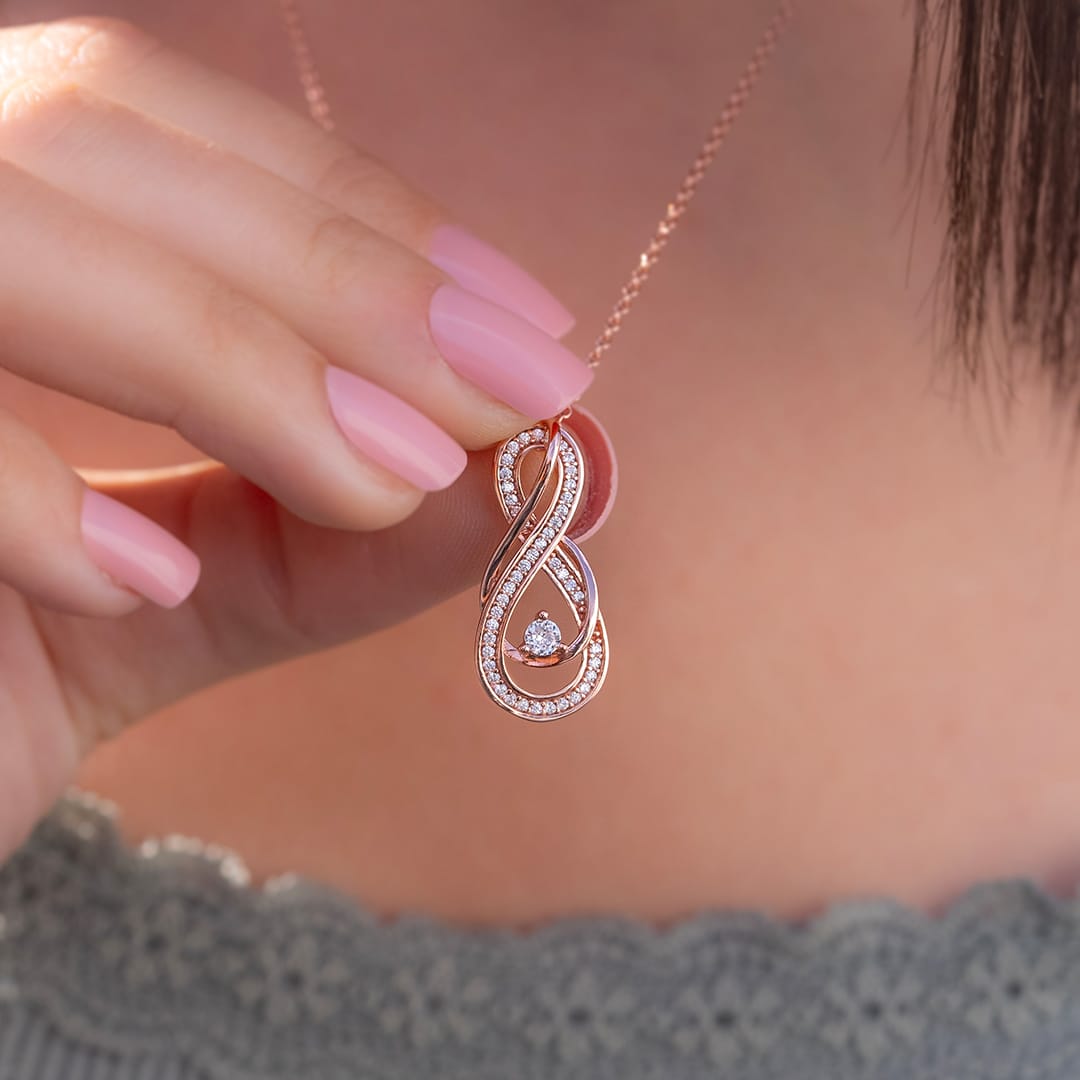 girl holding rose gold necklace