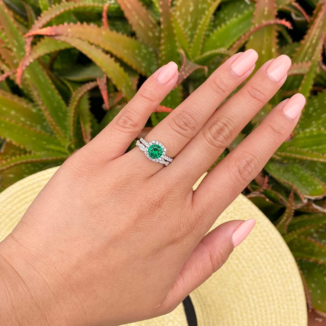 hand wearing emerald wedding ring set