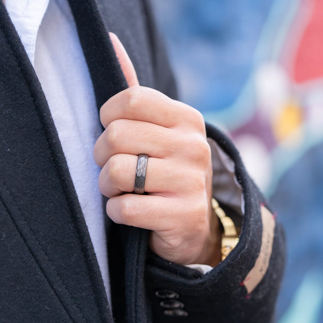 guy holding coat wearing wedding ring