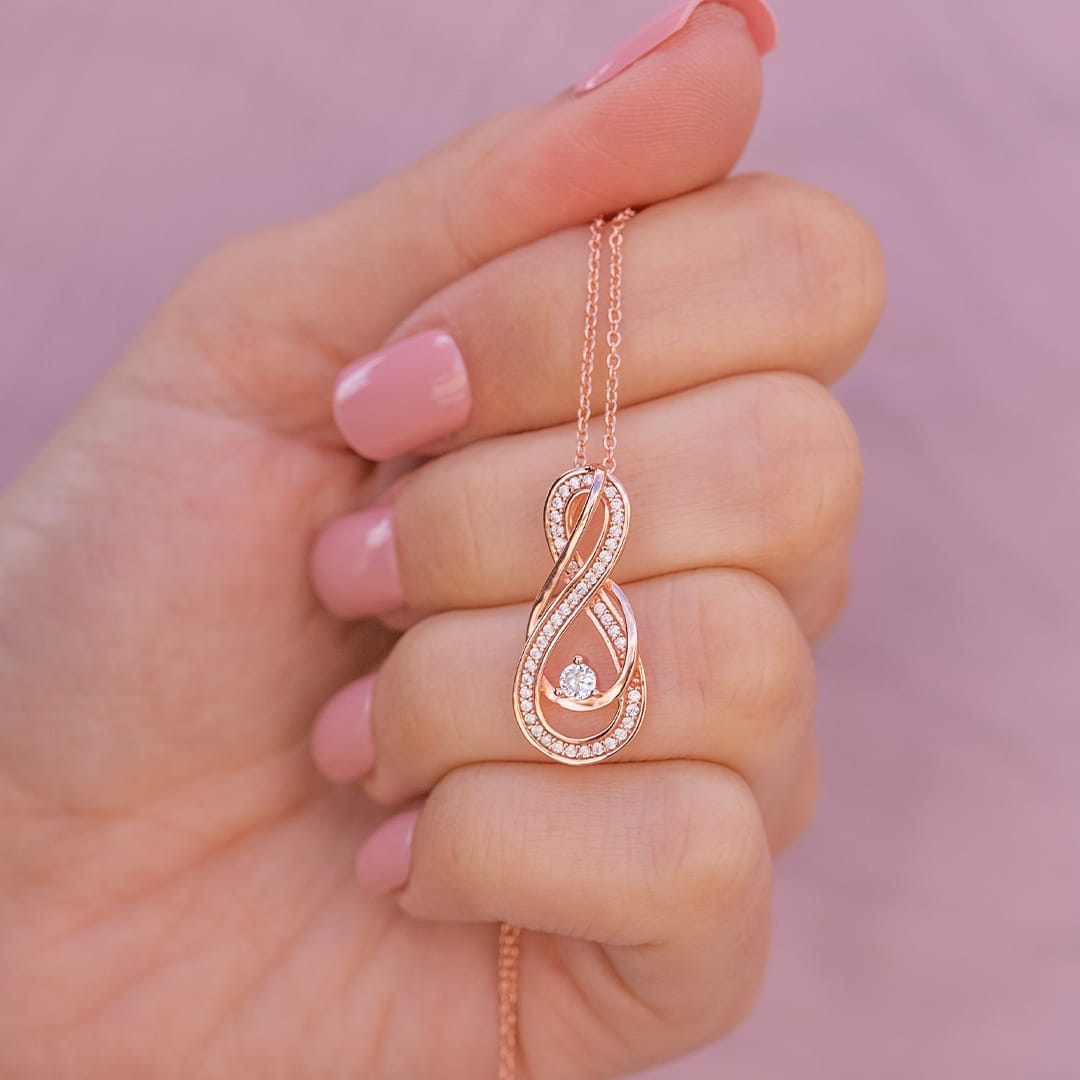 holding rose gold necklace