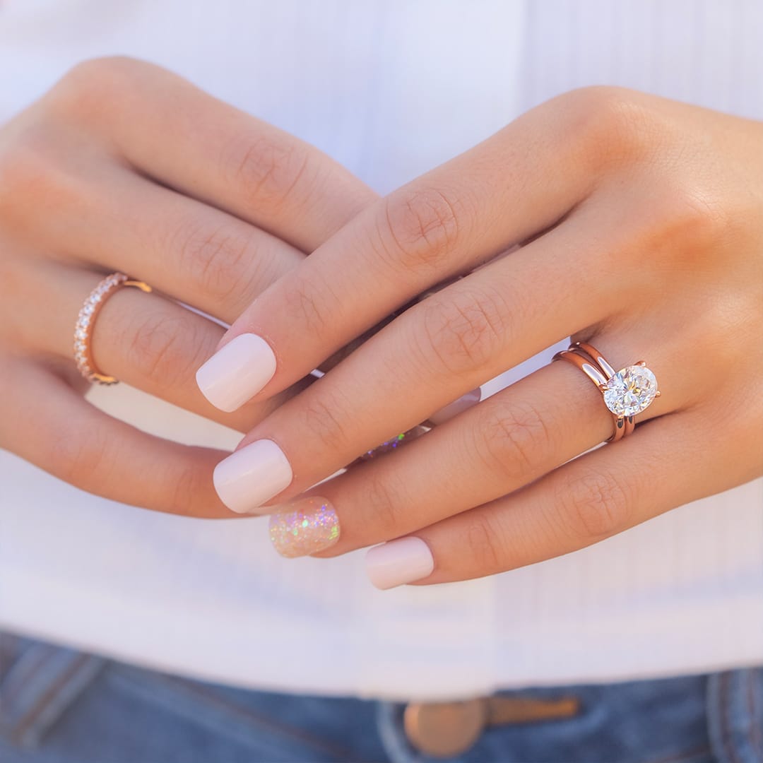 hand wearing rose gold wedding rings