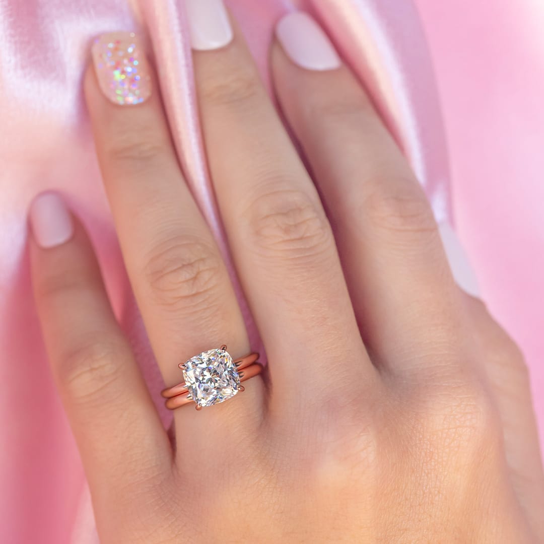 hand wearing solitaire rose gold rings