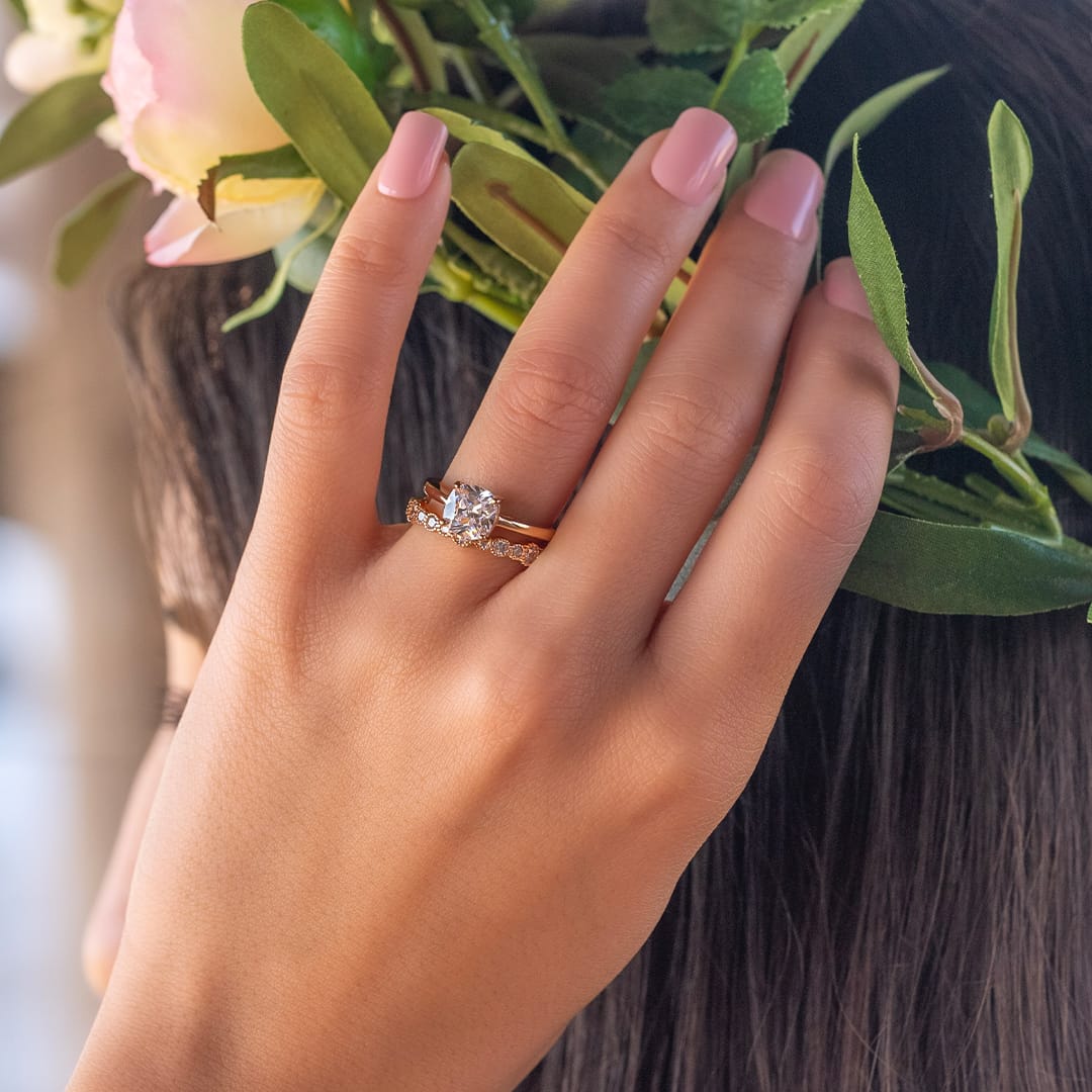 hand wearing wedding rings in rose gold